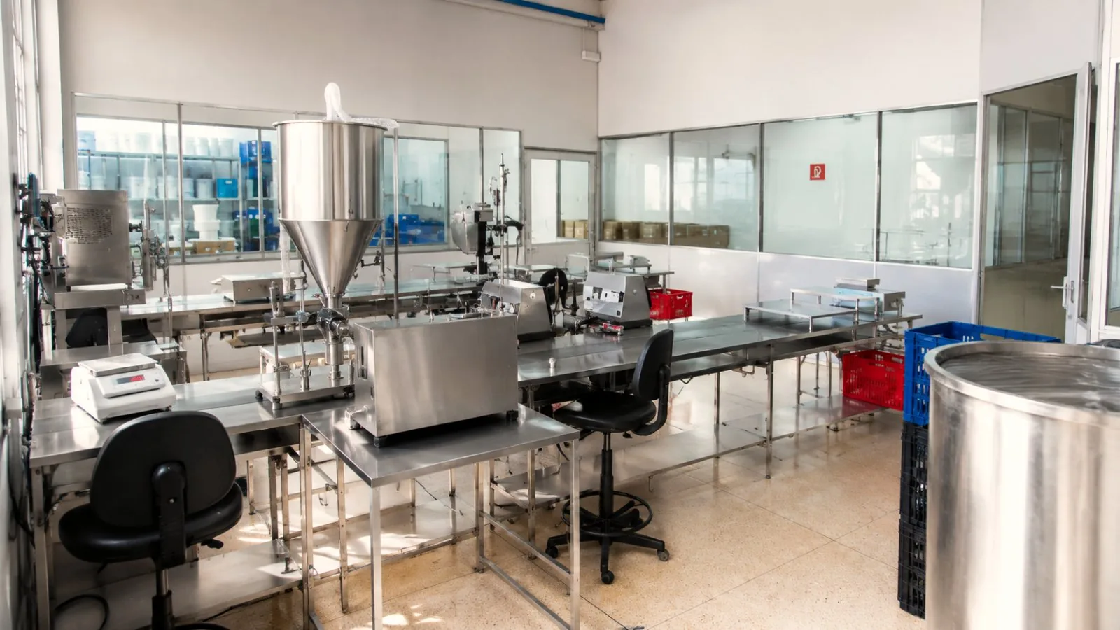 Línea de envasado de la fábrica Hibiscus — máquina de envasado y mesas de producción de cosméticos